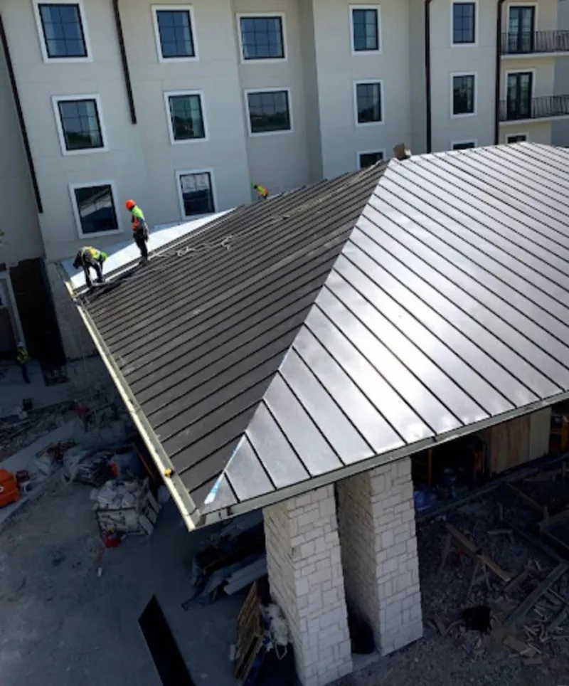 Crew installing standing seam metal roof panels on a commercial project in Port Charlotte
